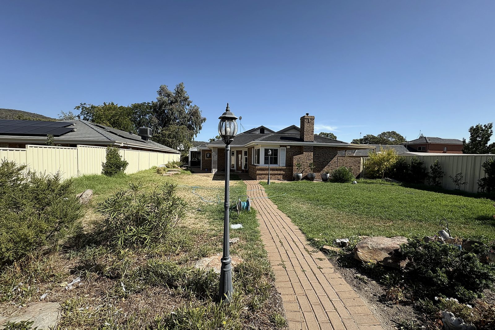 The garden before — patchy dry lawn and overgrown beds