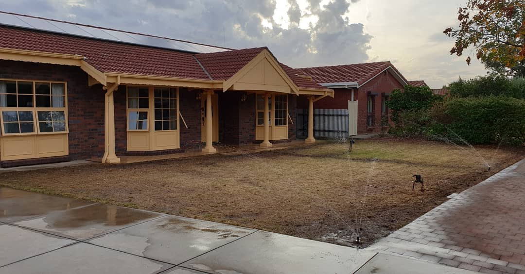 The front lawn before — bare dirt being watered in